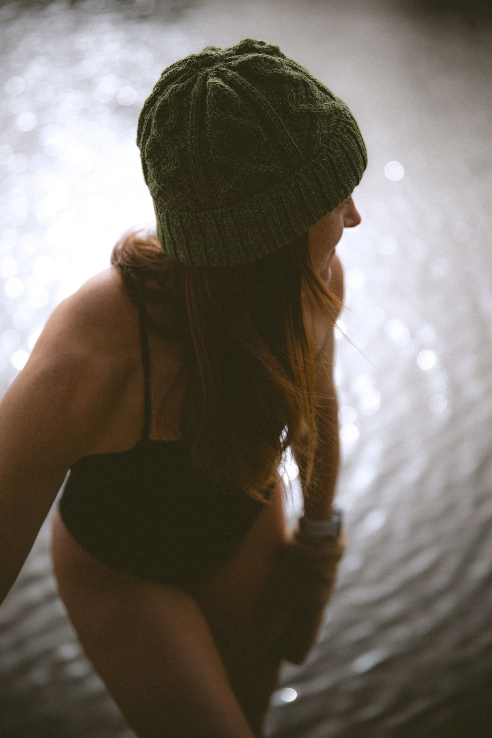Silhouette de dos au bonnet, face à l’eau, entre chaleur et fraîcheur