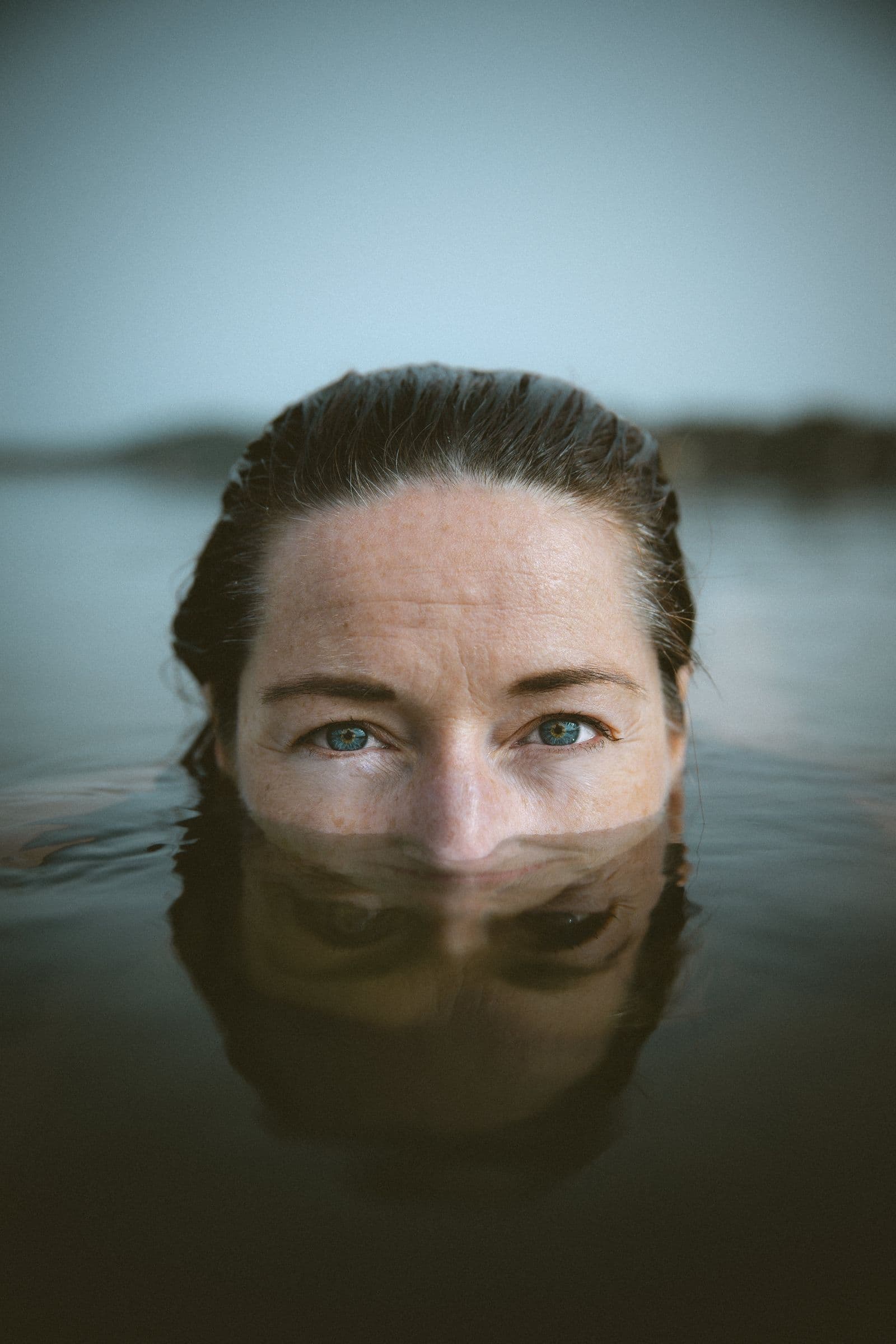 Une femme, le visage à fleur d’eau, lors d’une immersion en eau froide