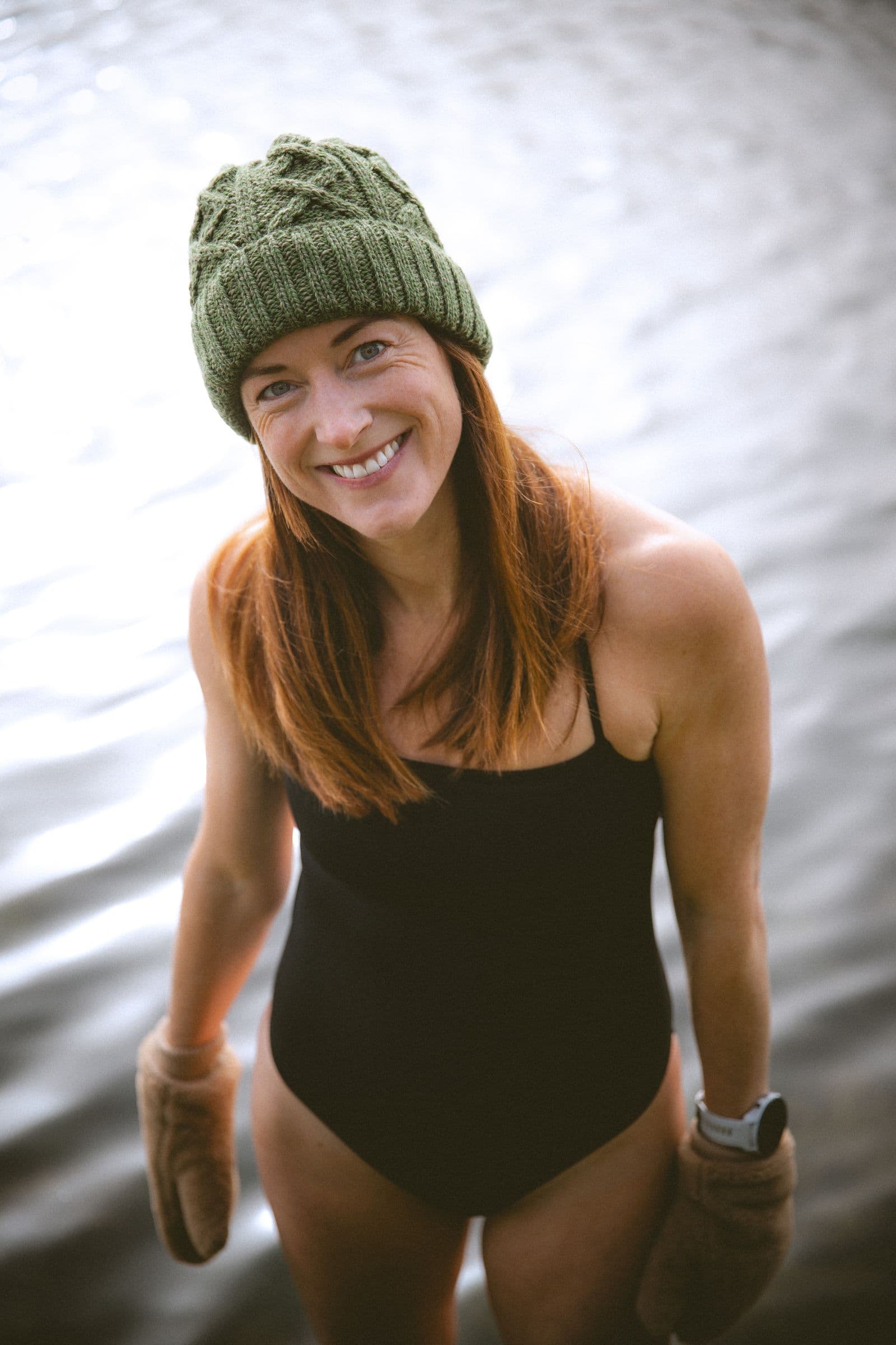Aisling, fondatrice de Nomad Sauna & Ice, souriante en bonnet au bord de l’eau
